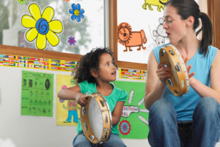 Teacher and Child playing with a drum