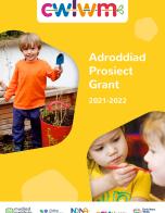 Adroddiad Prosiect Grant 2021- 22 Project Report Front Cover. Yellow Background with two photos including boy smiling while gardening and a girl holding a spoon up to another childs mouth